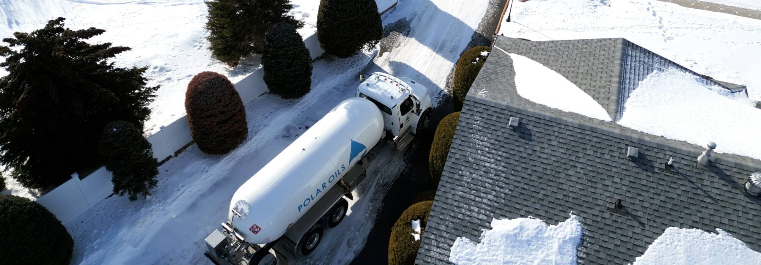 Truck delivering fuel in snowy landscape.