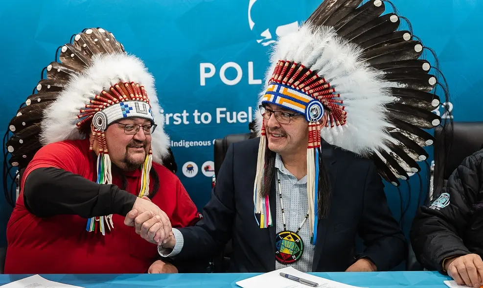 Two men in headdresses shaking hands