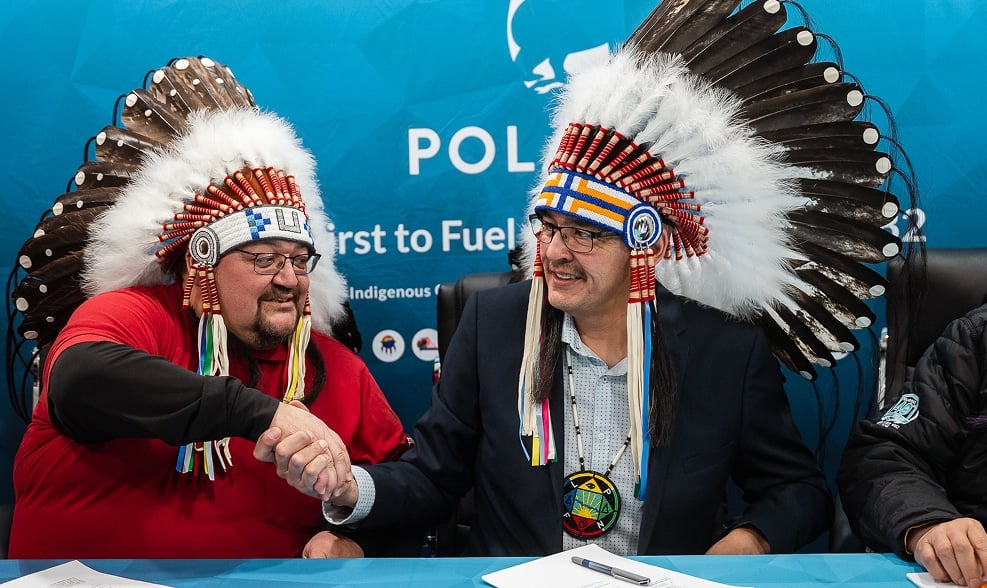 Two men in headdresses shaking hands