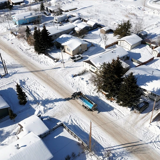Snowy residential area with delivery truck
