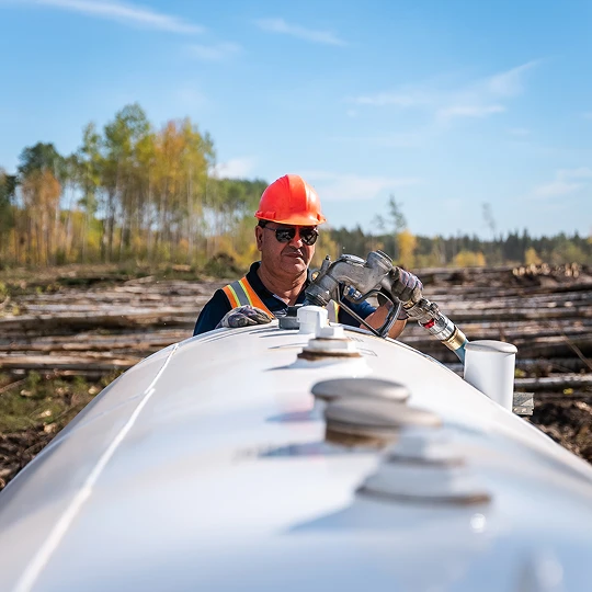 Man fuelling tank in forested area